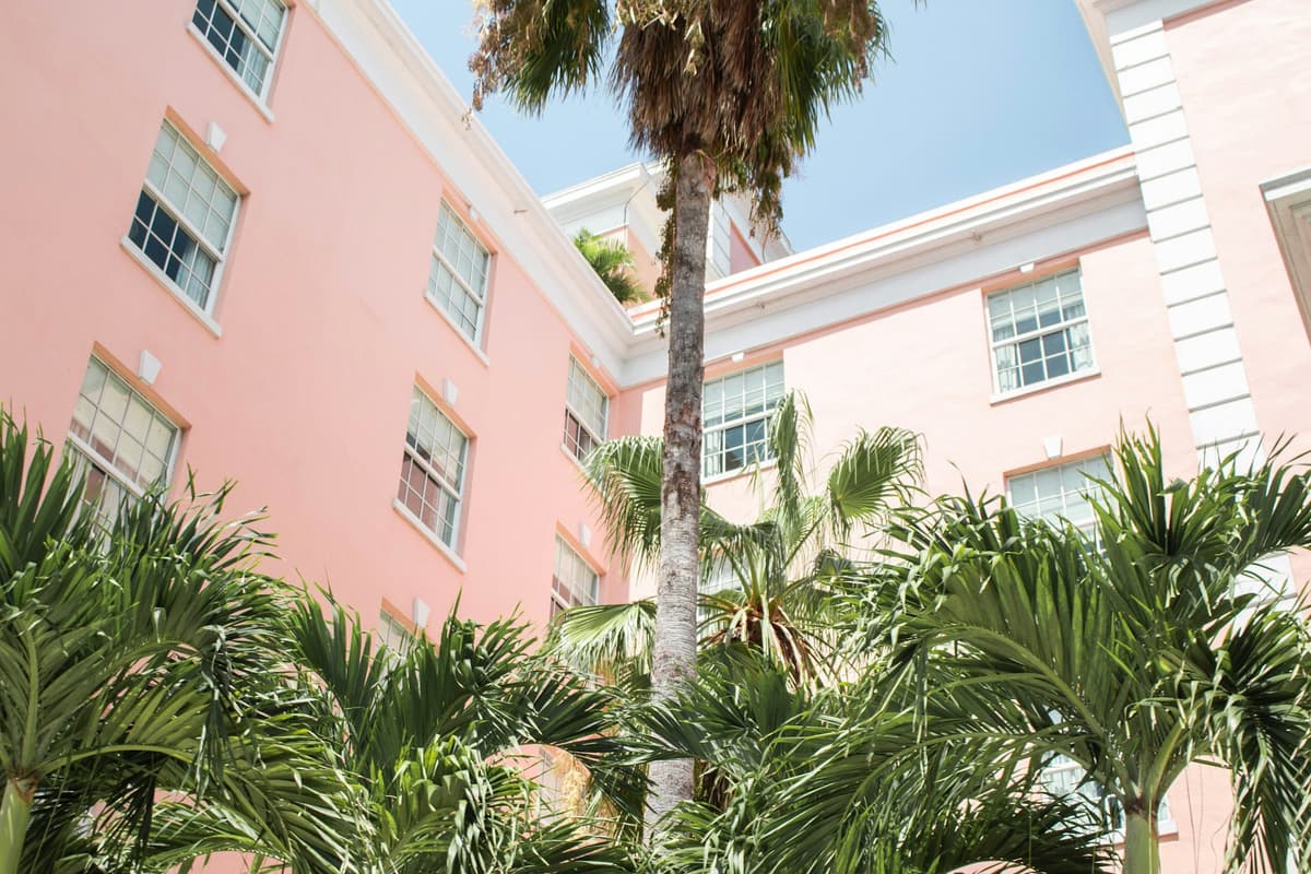 A pink building framed by palm trees in Palm Beach